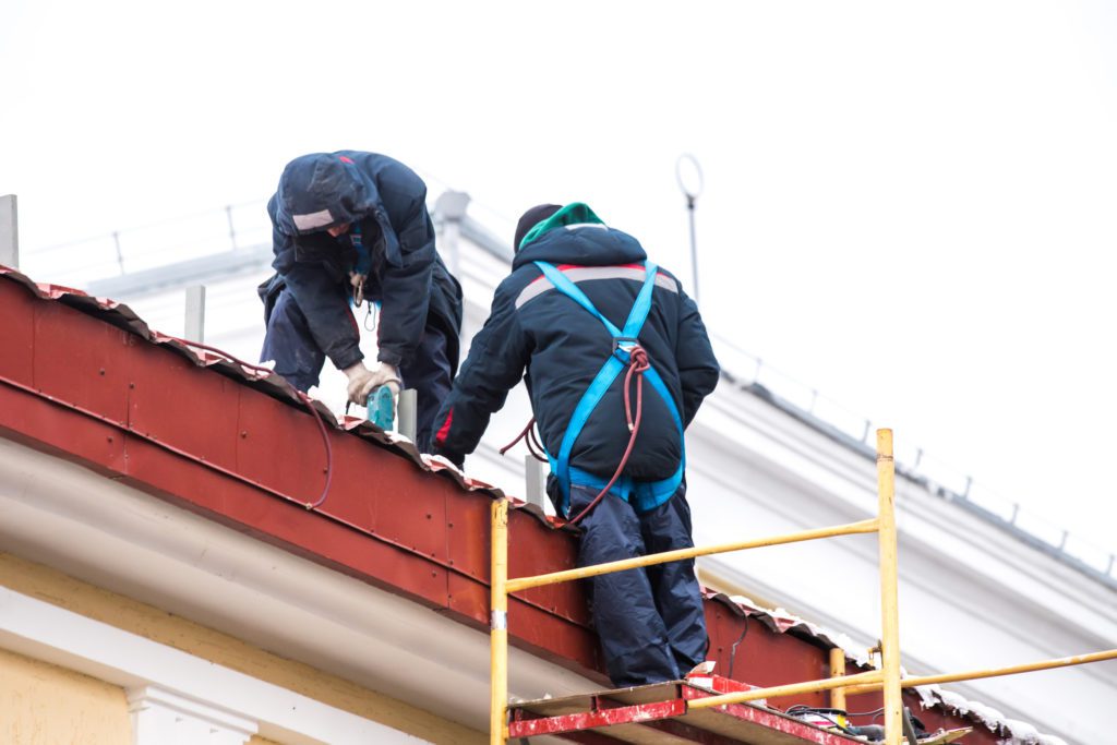 Two high-altitude workers work on the roof with insurance, roofing, commercial roofing, roof, roof replacement, roof repair